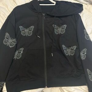 black zip-up hoodie with a hood and with butterflies